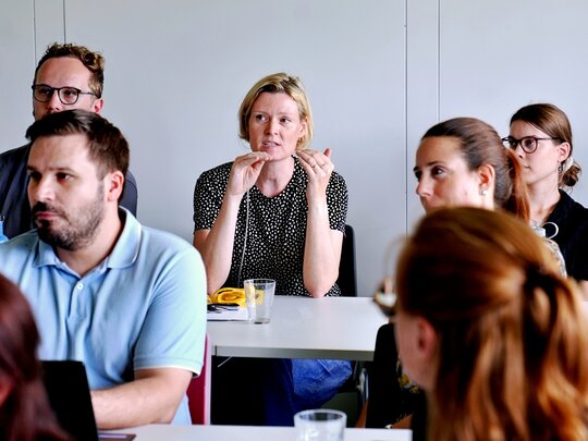 Junge Forschende aus dem Publikum diskutieren beim Nachwuchskolloquium 2026 der Fakultät III