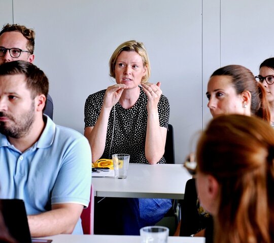 Junge Forschende aus dem Publikum diskutieren beim Nachwuchskolloquium 2026 der Fakultät III