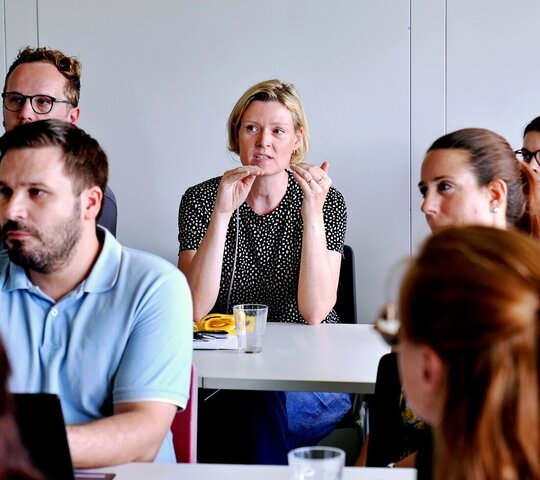 Junge Forschende aus dem Publikum diskutieren beim Nachwuchskolloquium 2026 der Fakultät III