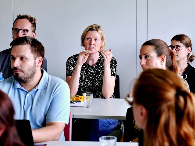 Junge Forschende aus dem Publikum diskutieren beim Nachwuchskolloquium 2026 der Fakultät III