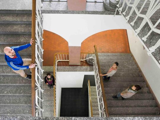 Blick von oben auf Personen im Treppenhaus.