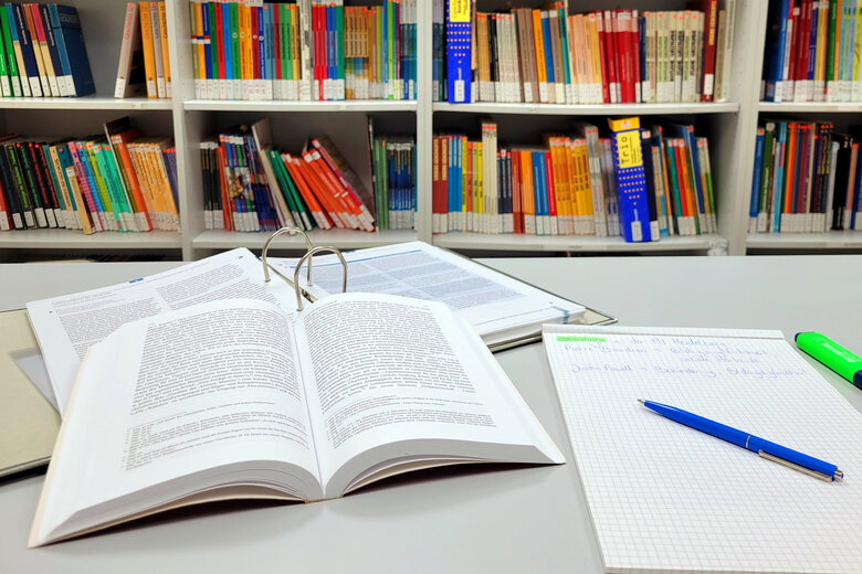 Foto der Bücher und eines Notizblocks aud dem Schreibtisch
