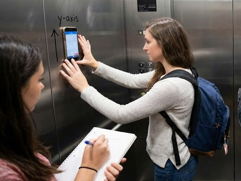 Studierende bei einem Experiment im Fahrstuhl: Mit ihrem Handy messen sie die Geschwindigkeit