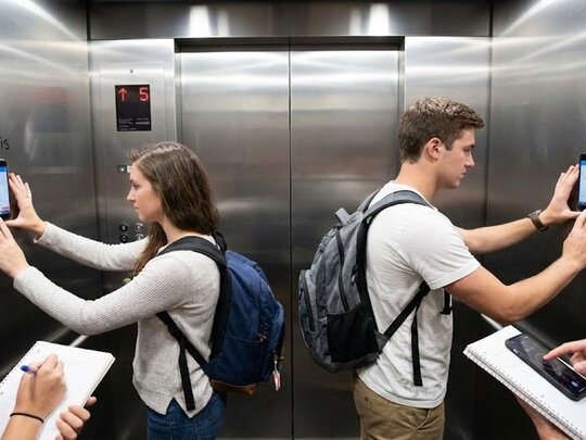 Studierende bei einem Experiment im Fahrstuhl: Mit ihrem Handy messen sie die Geschwindigkeit
