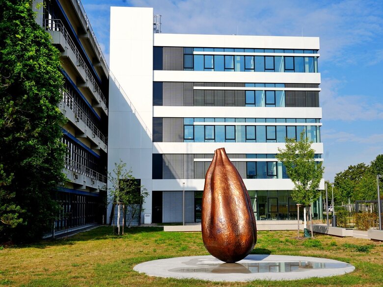 Zu sehen ist das neue Kunstwerk "Seed" vor dem C-Bau