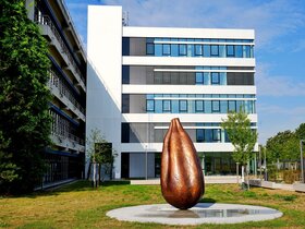 Zu sehen ist das neue Kunstwerk "Seed" vor dem C-Bau