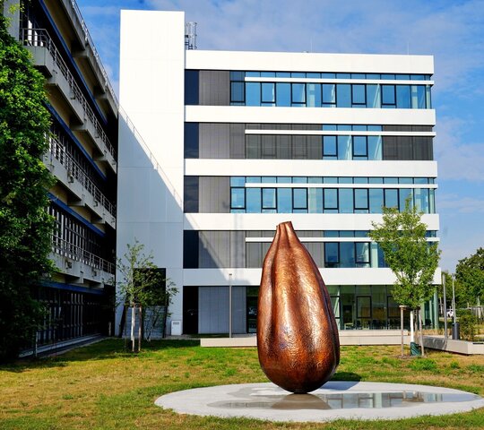Zu sehen ist das neue Kunstwerk "Seed" vor dem C-Bau