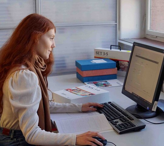 Eine Frau sitz am Computer. 
