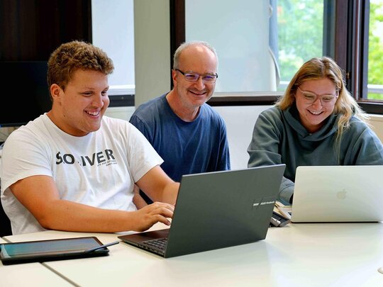 [Übersetzen nach: English] Zwei Studierende und ein Dozent der Pädagogischen Hochschule Heidelberg arbeiten gemeinsam in einer Lehrveranstaltung vor ihren Laptops. 