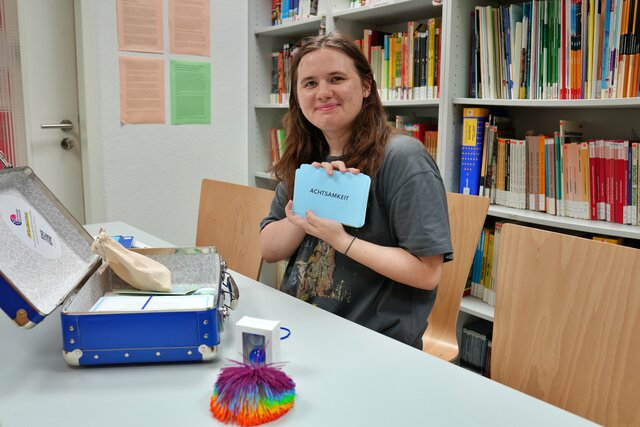Foto einer Studentin mit dem offenen Koffer
