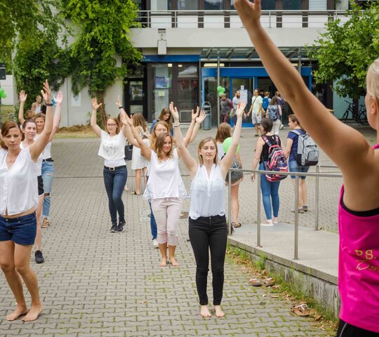 Zu sehen ist eine Gruppe an Menschen, die gemeinsam Sport machen.