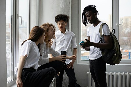Jugendliche mit Handy im Gespräch