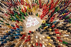 verschiedenfarbige Spielfiguren aufgestellt mit kleinen Zetteln in Ihrer Mitte.