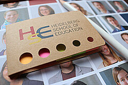 Das Bild zeigt eine Schachtel mit dem Aufdruck der HSE (Heidelberg School of Education). Copyright Pädagogische Hochschule Heidelberg