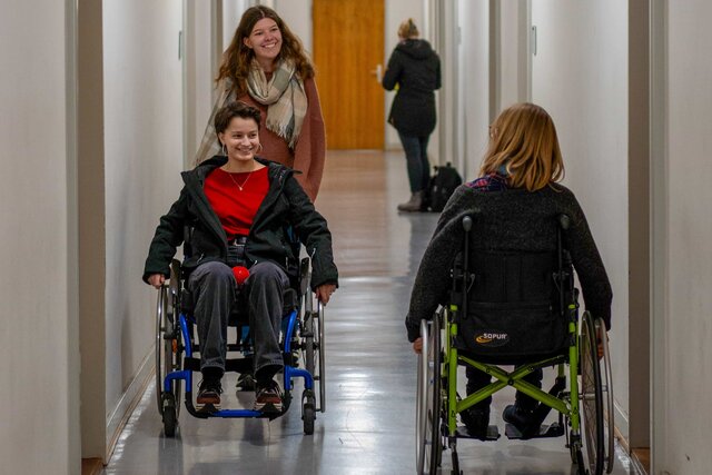 Das Bild zeigt Studentinnen, die im Rollstuhl sitzen und den Selbsterfahrungsparcours mitmachen.