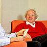 Auf dem Bild ist primär Herr Professor i.R. Dr. Buck zu sehen, der auf einer Couch sitzt. Vorne links ist Professor Dr. Gervé im Profil zu sehen. Copyright: Pädagogische Hochschule Heidelberg.