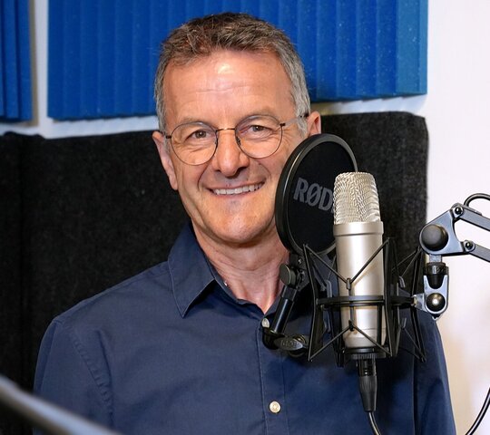 Zu sehen ist Prof. Dr. Markus Lang beim Gespräch über Brailleschrift im Podcast-Studio der PHHD.