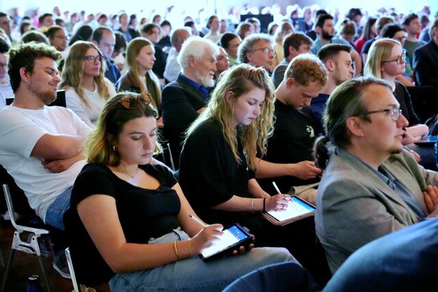 Zu sehen ist das sitzende Publikum.