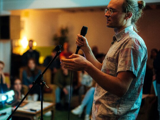 Zu sehen ist ein Wissenschaftler bei einem Science Slam.