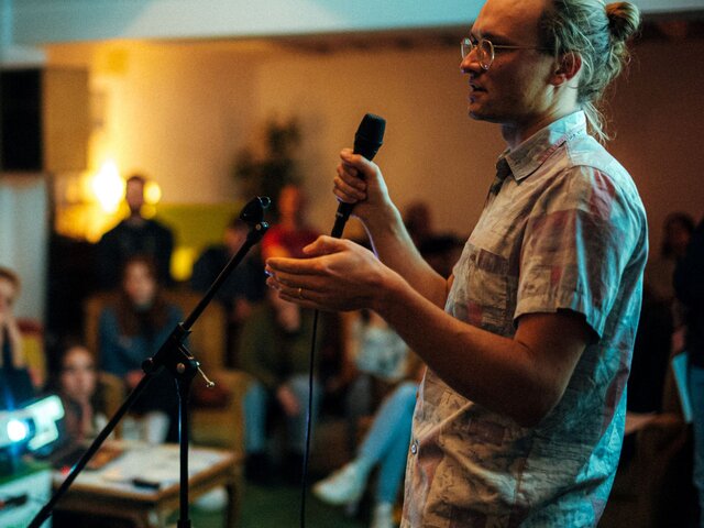 Zu sehen ist ein Wissenschaftler bei einem Science Slam.
