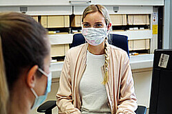 Das Bild zeigt eine Mitarbeiterin des Studienbüros der Hochschule, die eine andere Frau berät. Beide tragen aufgrund der Corona-Pandemie eine Maske. Copyright Pädagogische Hochschule Heidelberg