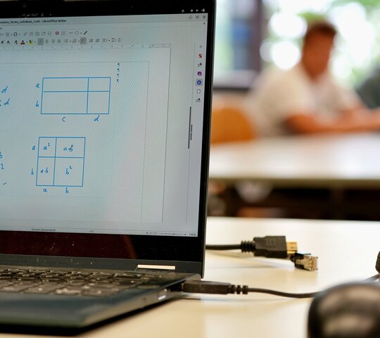 Zu sehen ist ein aufgeklappter Laptop.
