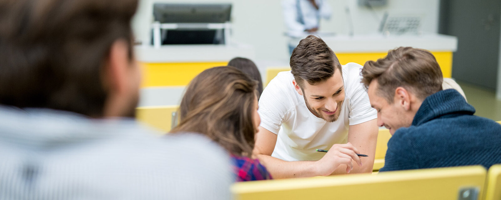Drei Studierende planen gemeinsam im Hörsaal ihren Auslandsaufenthalt.