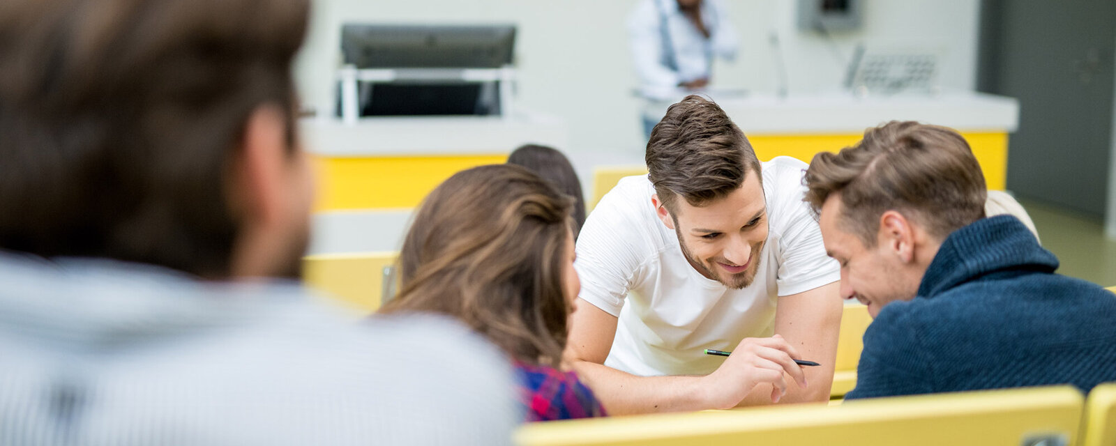 Drei Studierende planen gemeinsam im Hörsaal ihren Auslandsaufenthalt.