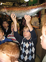 Bild von einem Schüler, der einen Fisch (Requisite) hochhält