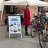 Fahrradreparaturstandeine Person repariert ein Fahrrad. Eine andere Person steht daneben und schaut zu.