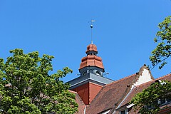 Der Altbauturm vor blauem Himmel