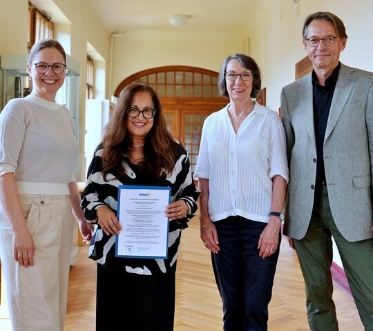 Das Gruppenfoto zeigt Shaireen Rasheed bei der Übergabe des Visiting-Professor-Zertifikats