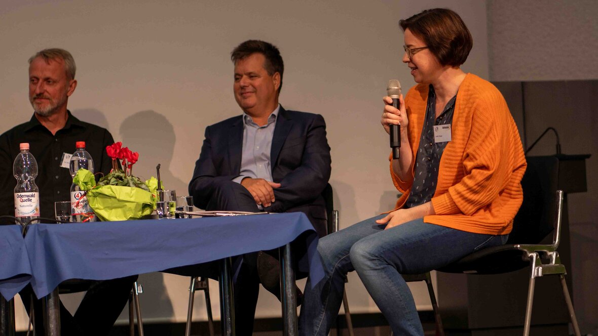 Das Bild zeigt Moderatorin Judith Rieger und zwei Teilnehmende der Podiumsdiskussion: Jürgen Dusel, Bundes-Beauftragter für die Belange von Menschen mit Behinderung sowie Dr. Jan Wiedemann, Vorstand der Stiftung Drachensee.