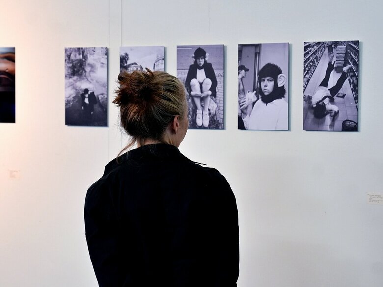 Zu sehen ist eine Frau von hinten vor der ausgezeichneten Fotoserie