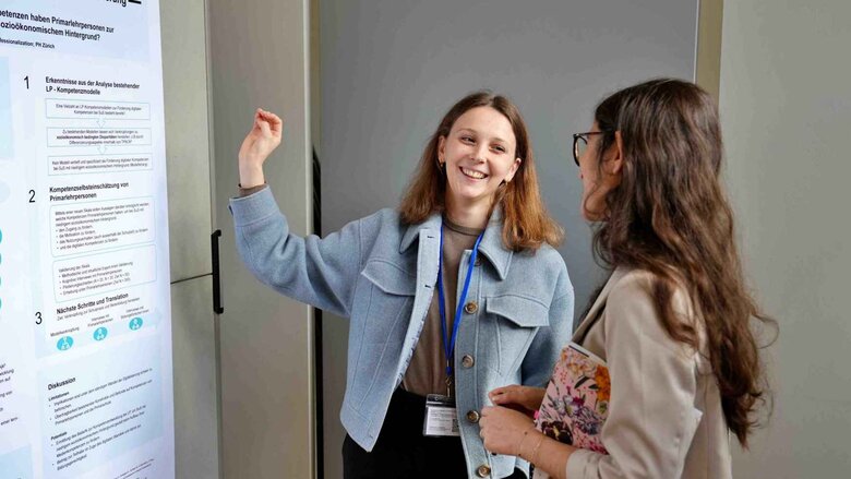 Zwei Frauen stehen vor einem Forschungsplakat.