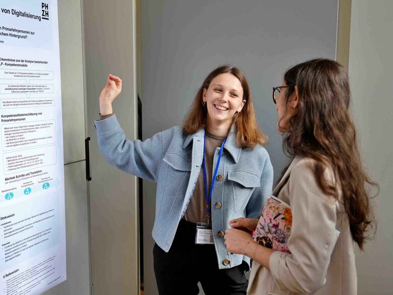Zwei Frauen stehen vor einem Forschungsplakat.