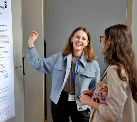 Zwei Frauen stehen vor einem Forschungsplakat.