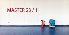 Ein Feuerlöscher steht neben einem Mülleimer mit blauer Mülltüte. Auf das Foto wurde in roter Schrift "MAster 23/1" geschrieben.