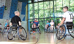 Das Foto zeigt Rollstuhlfahrer in der Sporthalle.