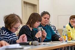 Das Bild zeigt die angehenden Bildungsfachkräfte Susann Bensch und Louisa Kabbe, die mit Assistenz der Qualifizierungsleiterin Noemi Heister ein Bildungsangebot ausbringen.