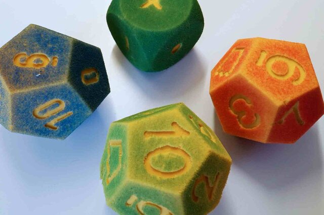Es sind vier schaumstoffförmige Würfel zum Spielen und Rechnen zu sehen. 
