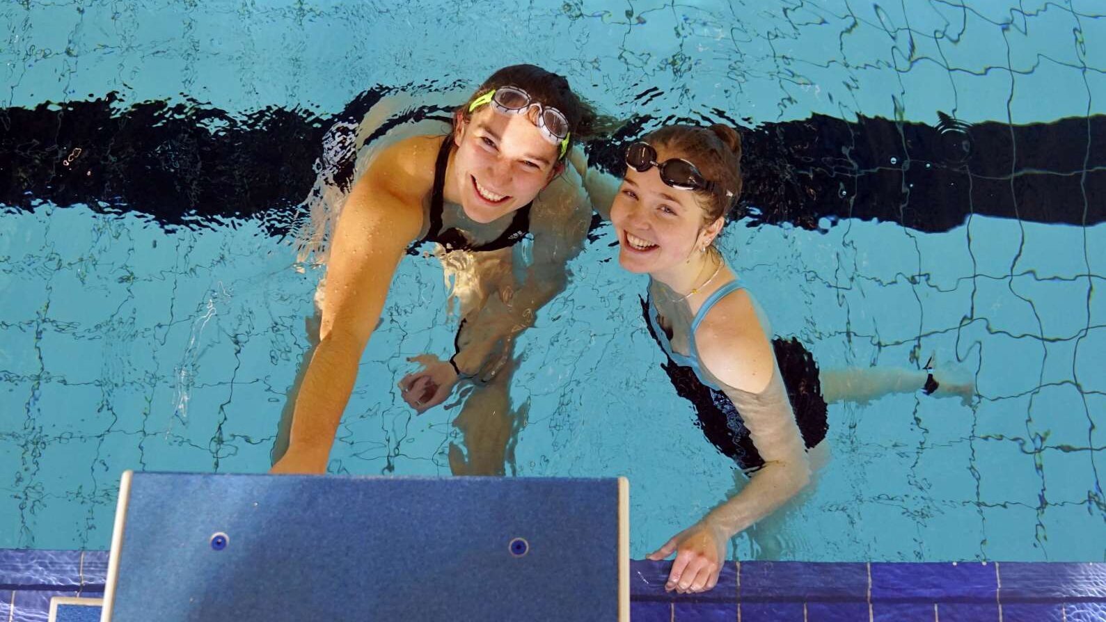 Zu sehen sind zwei junge Frauen im Wasser.