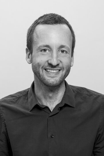 Zu sehen ist ein Portraitfoto in schwarz-weiß von Jan Kircher