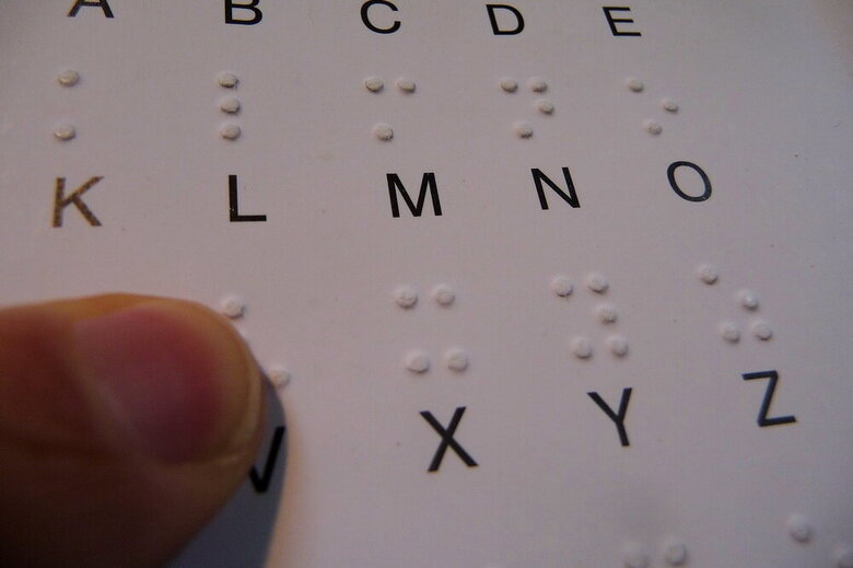 Ein Finger berührt einen Braille-Buchstaben