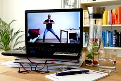 Das Bild zeigt eine Frau beim Sport machen auf dem Bildschirm eines Laptops.