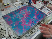 Das Bild zeigt ein Farbenexperiment, die Vermischung der Farben Blau und Rosa auf einem Tablett.