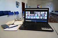 Das Bild zeigt einen Laptopbildschirm, auf dem das AW-ZIB-Team in einer Video-Konferenz zu sehen ist. Der Laptop steht im Senatssaal der Hochschule. Copyright: Pädagogische Hochschule Heidelberg
