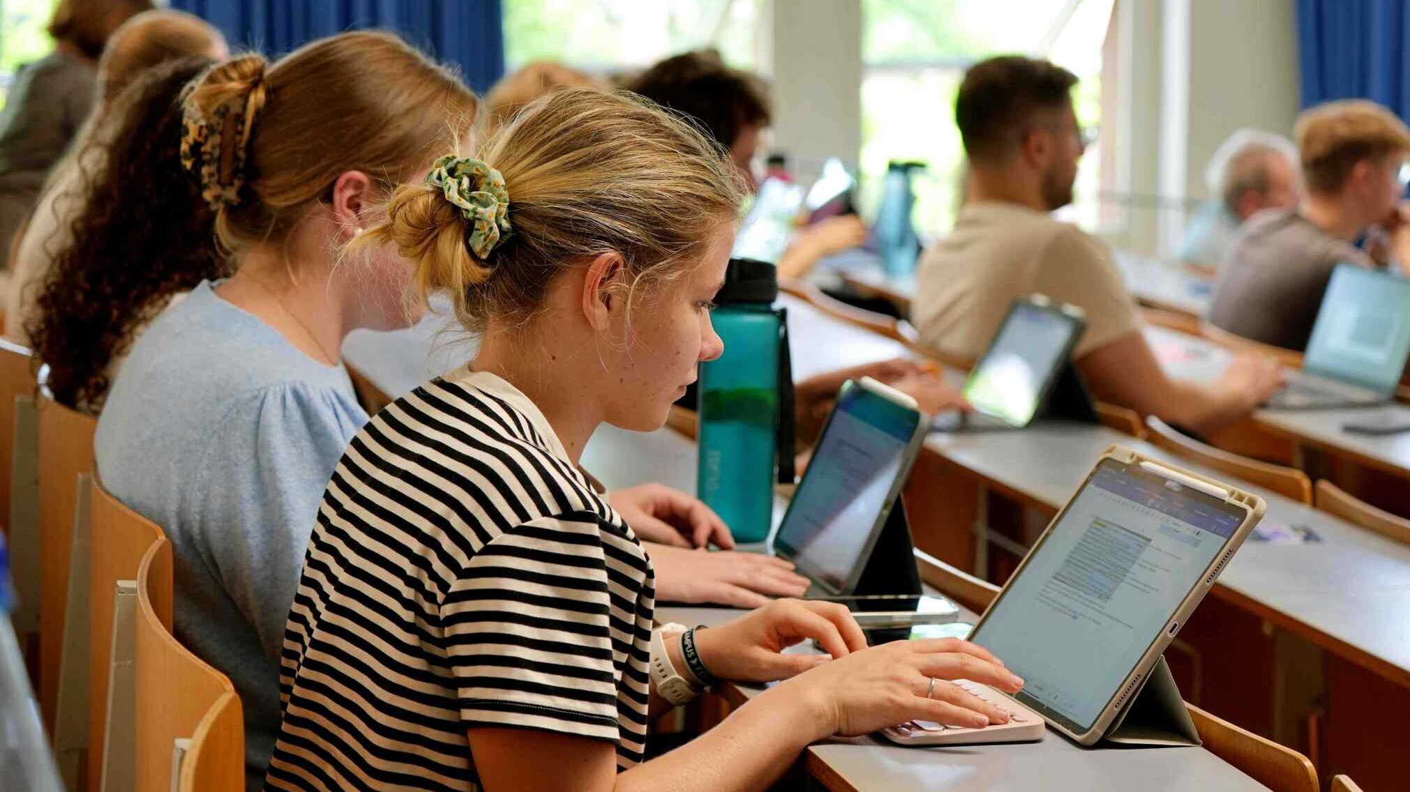 Studentinnen sitzen im Hörsaal.