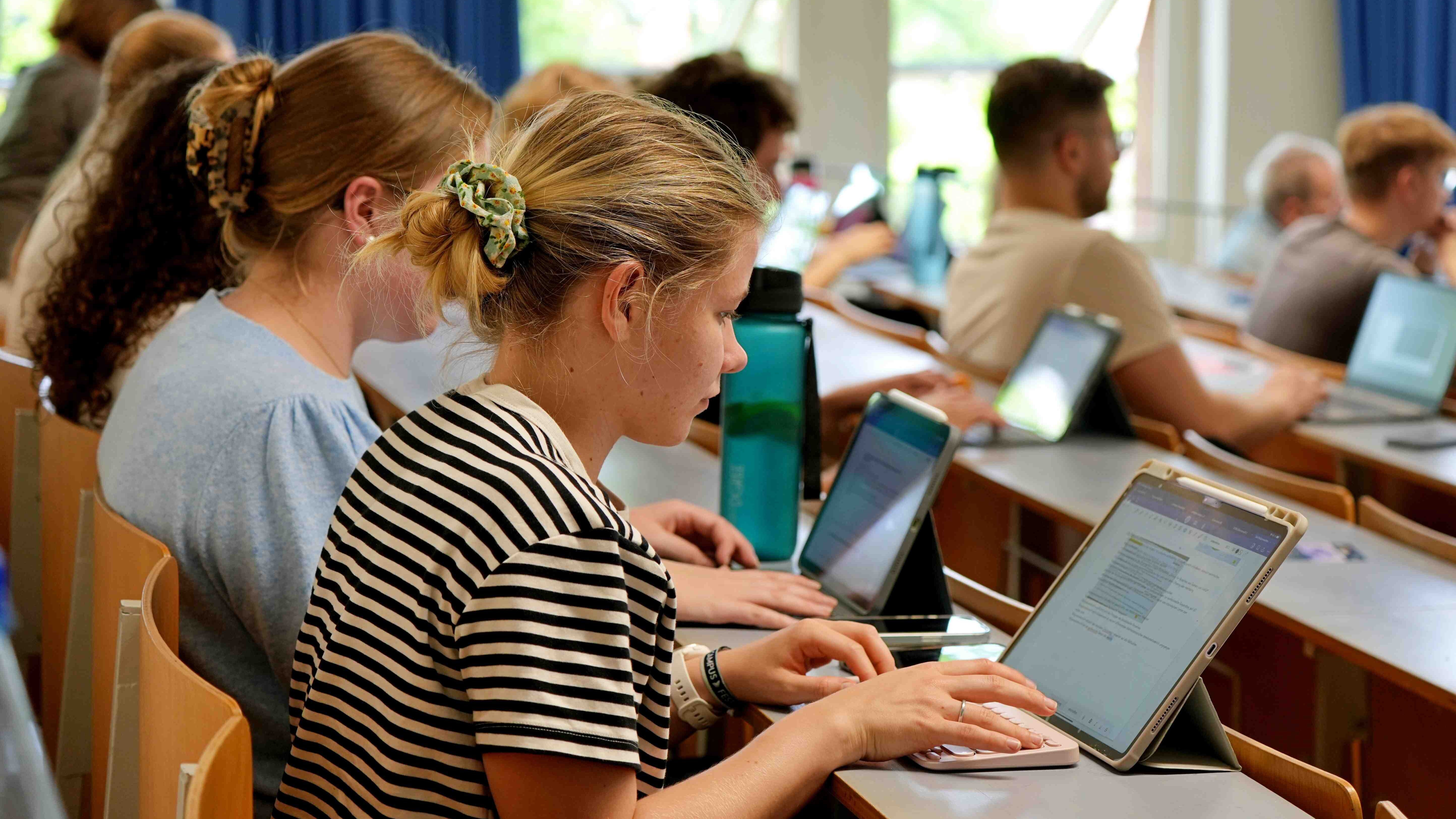 Studentinnen sitzen im Hörsaal.