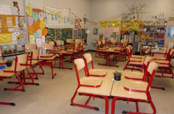 Das Bild zeigt einen Klassenraum mit hochgestellten Stühlen.
